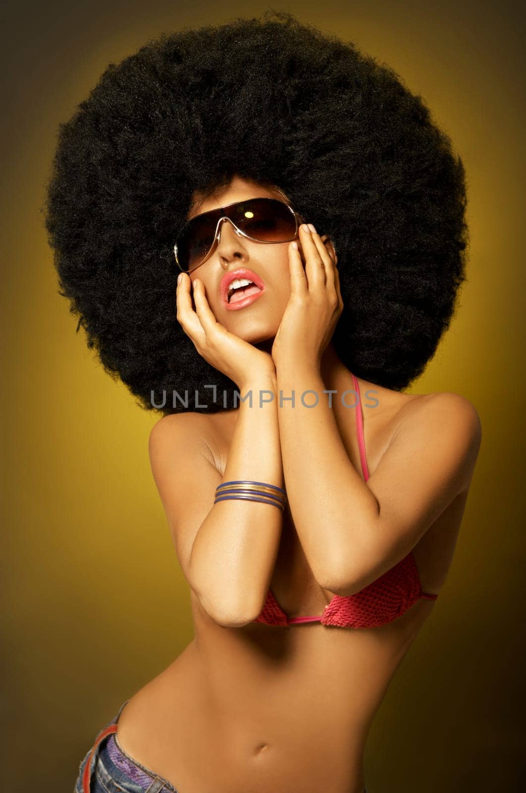 Beautiful woman with huge afro haircut on yellow