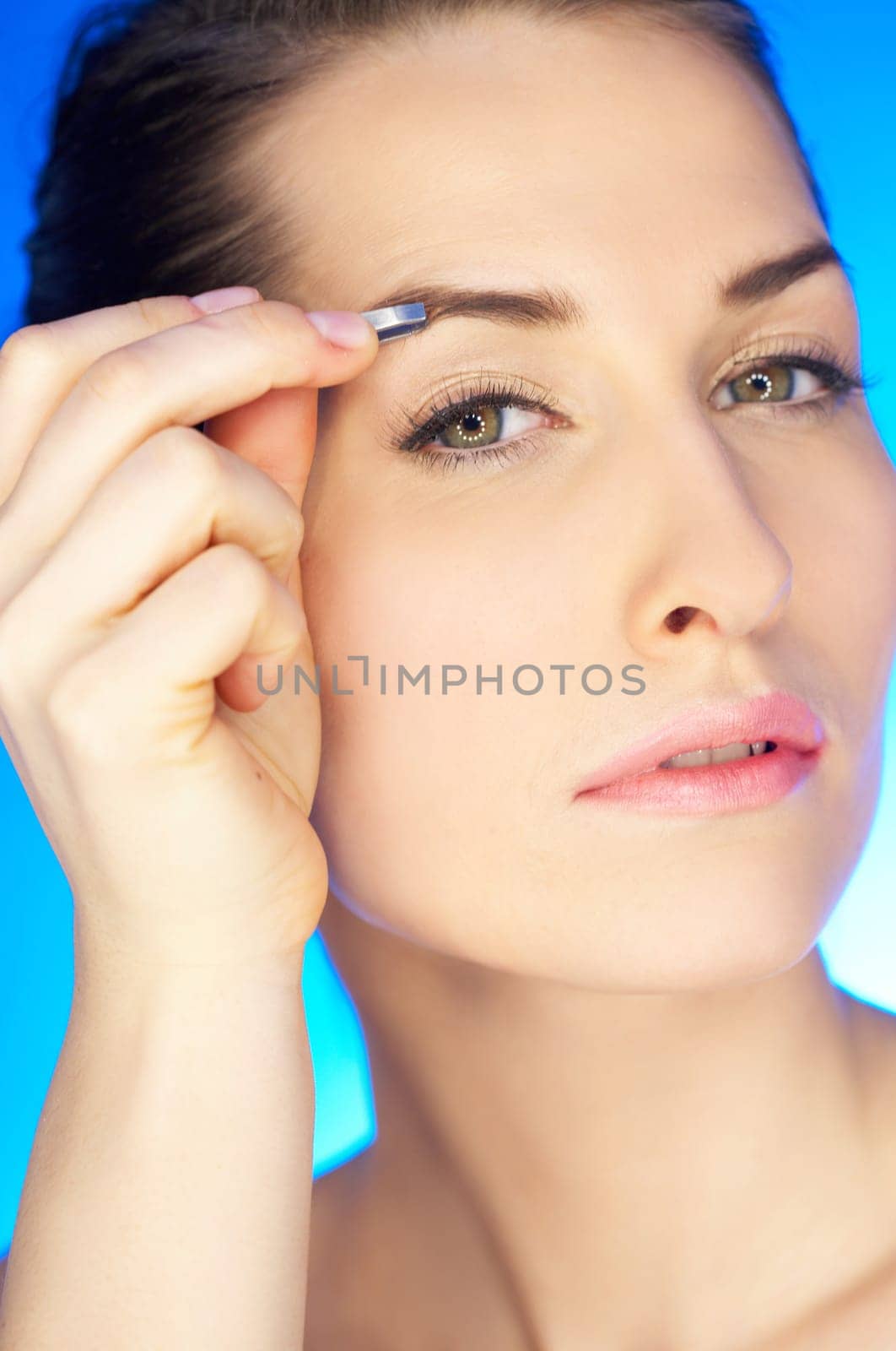 Portrait of beautiful woman with tweezers
