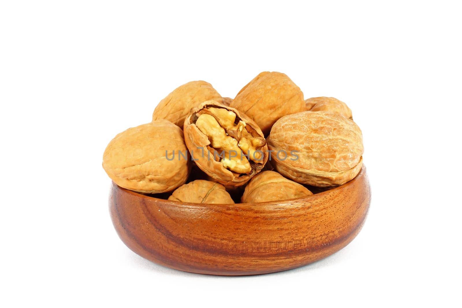 Walnuts in wooden bowl isolated on white