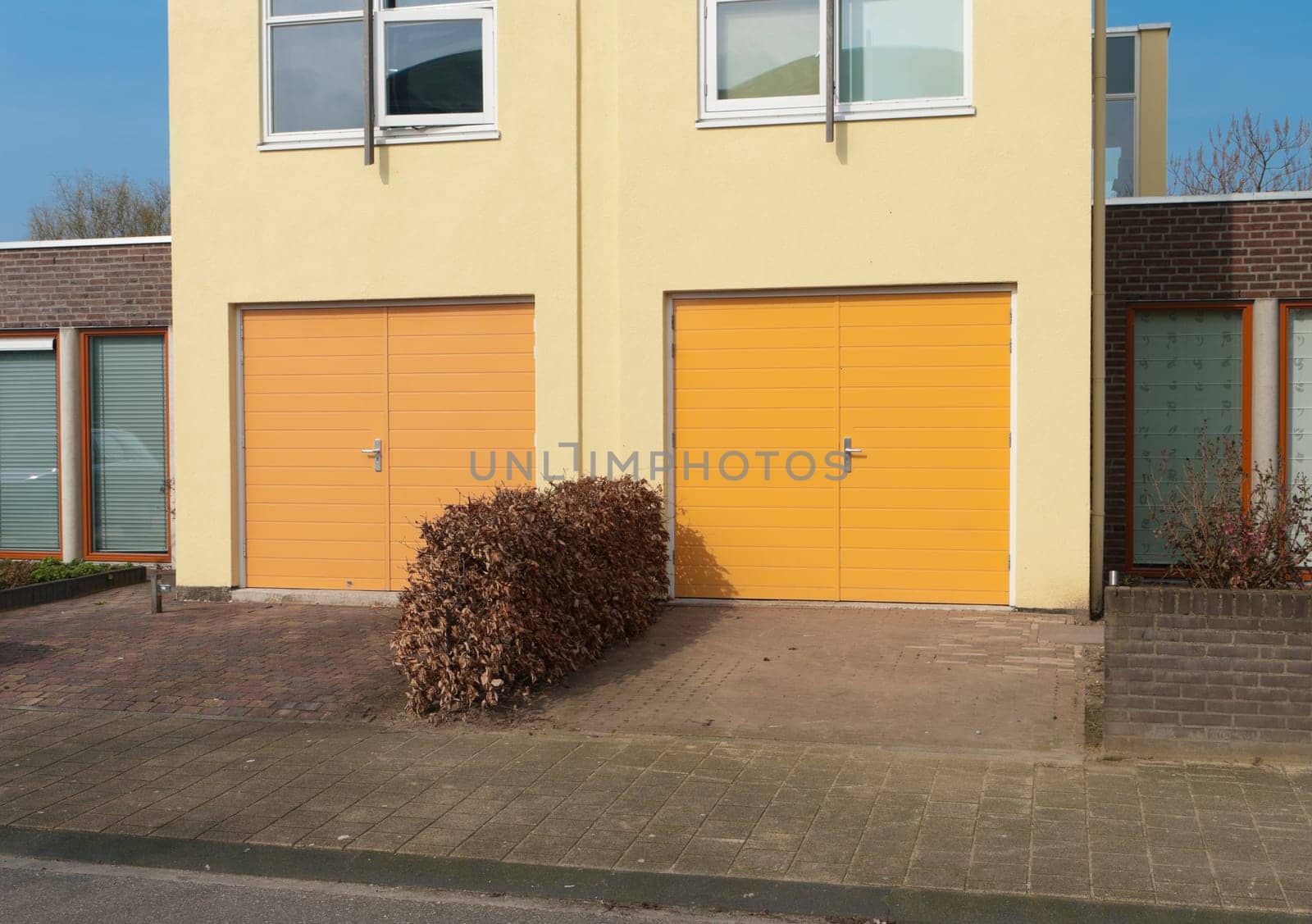 two yellow garage doors in the lower part of a house
