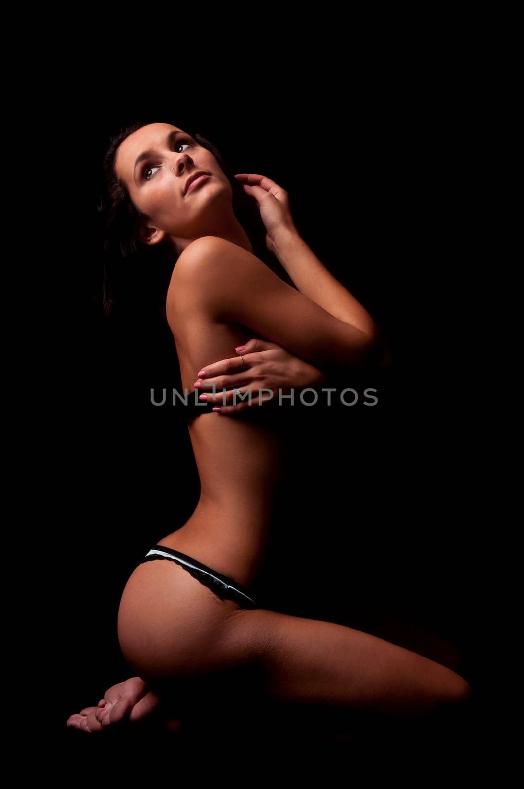 Beautiful young woman posing in lingerie in a dark background
