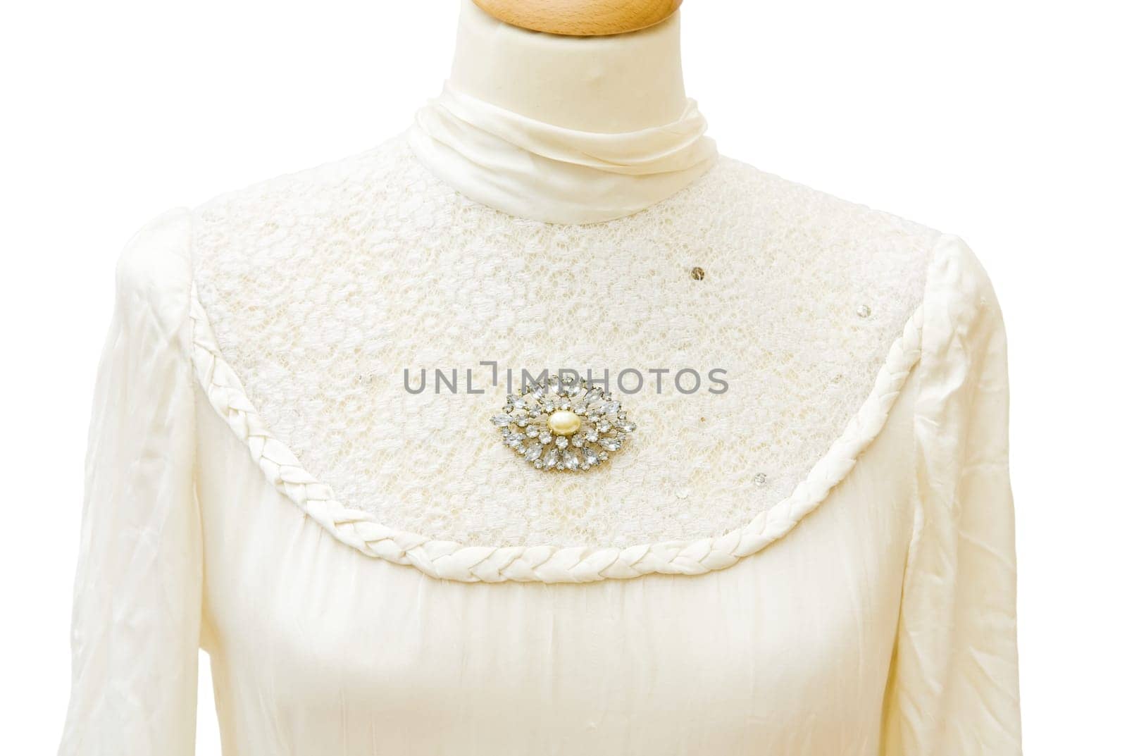 Genuine 1930 white satin bride dress. Jewellery vintage brooch with diamonds. Detail on the lace. Isolated over white background.