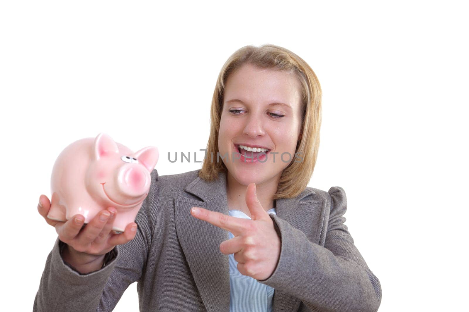 Young woman pointing at piggy bank in her hand