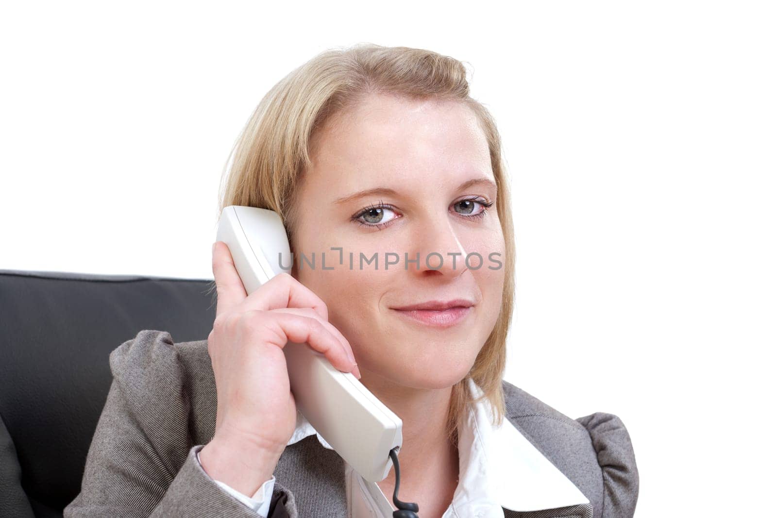 Young businesswoman talking on the phone looking at camera