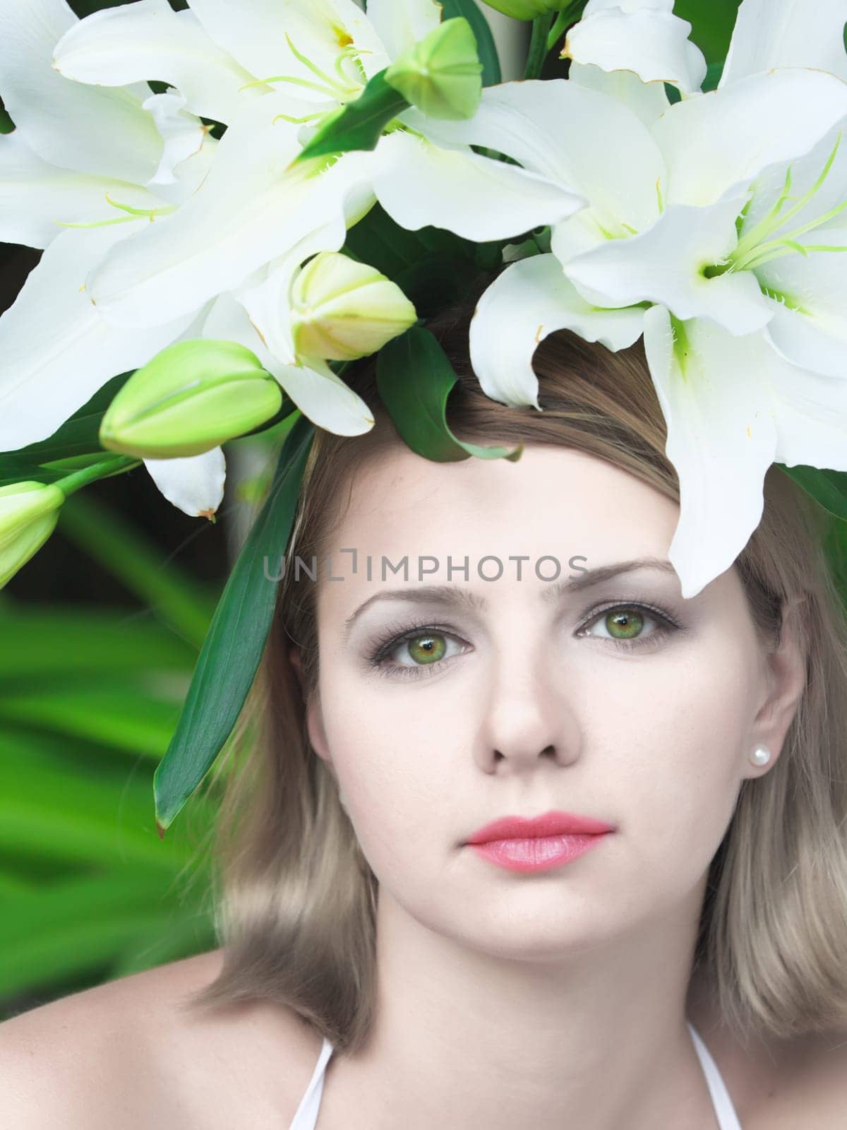 Close-up portrait of young beautiful woman with lily flowers