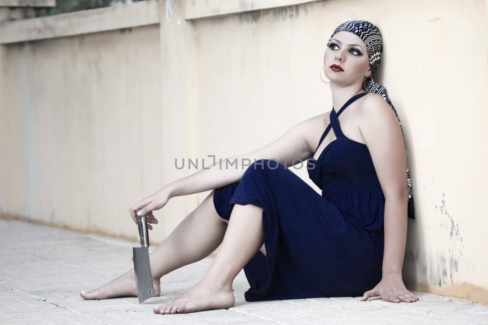 Woman with knife sitting on the street