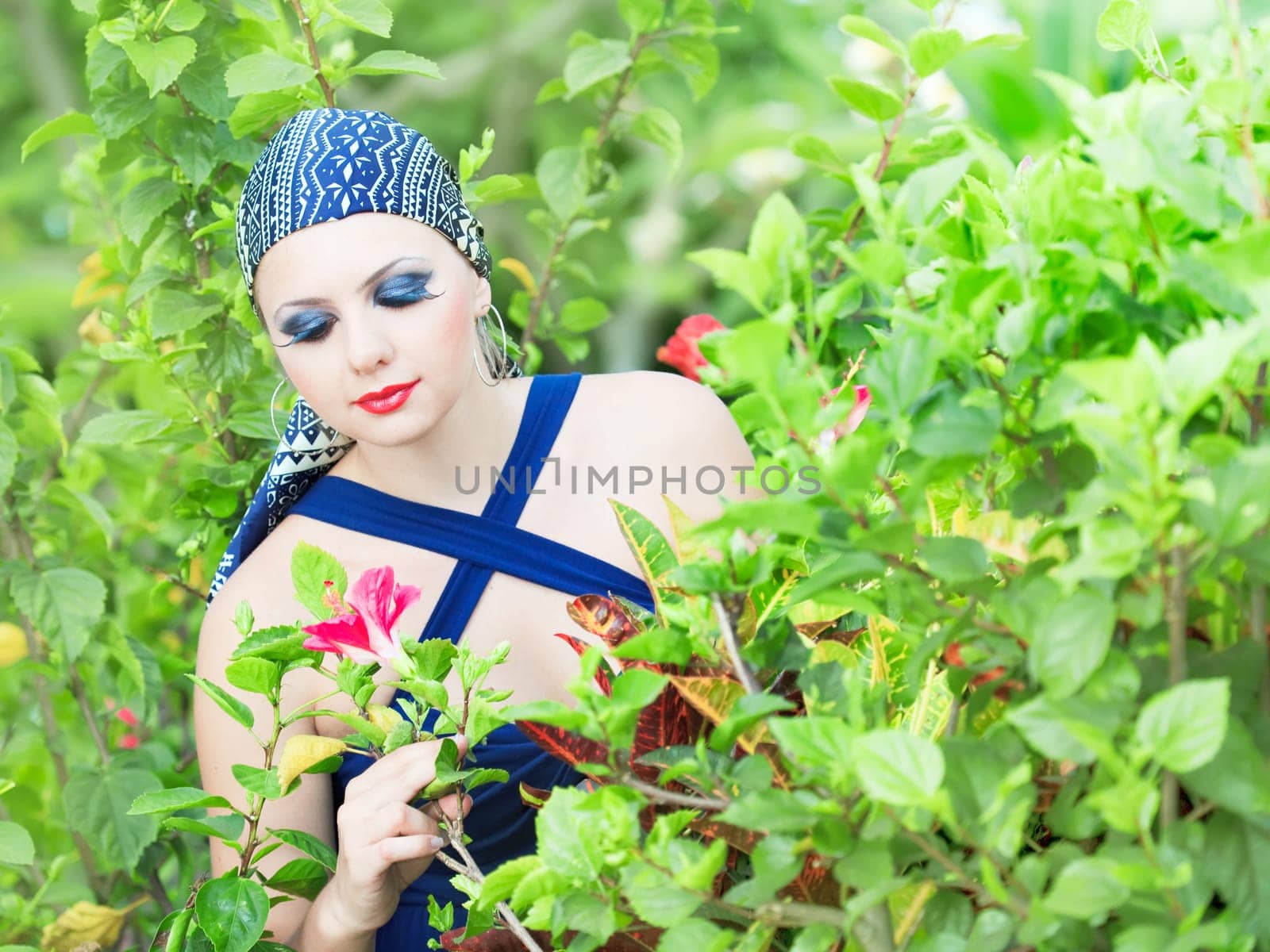 Young woman with creative make-up at flower garden