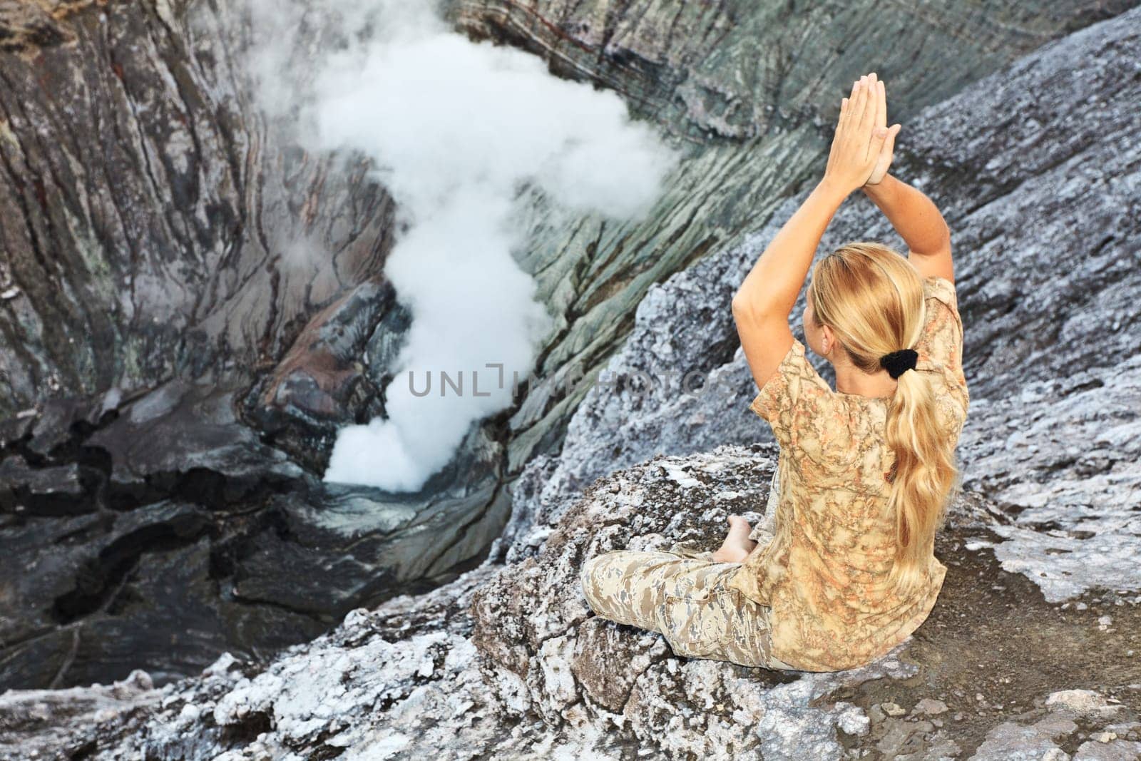 Woman meditatingat the crater of volcano Bromo. Java. Indonesia