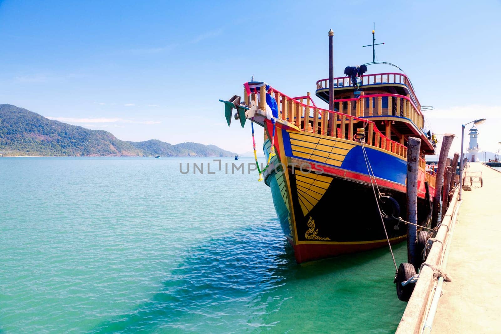 Traditional Thai tour boat tied at the pier on Koh Chang Island in Thailand