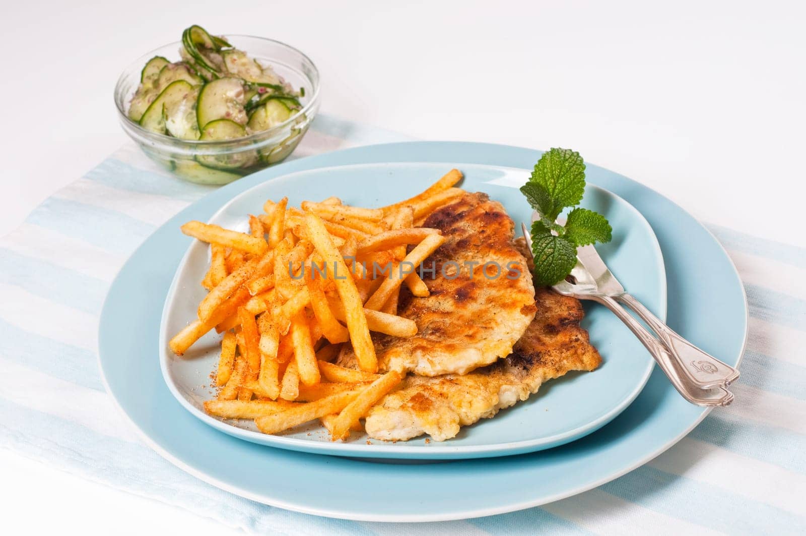 Fish fillet with fries on blue plate