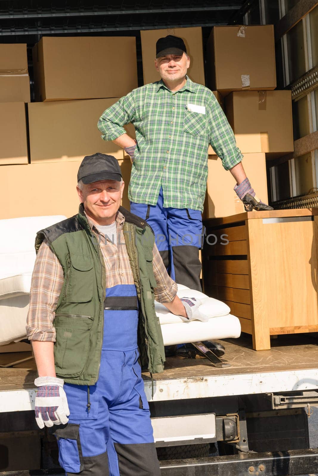 Two movers man loading furniture and boxes from truck vehicle