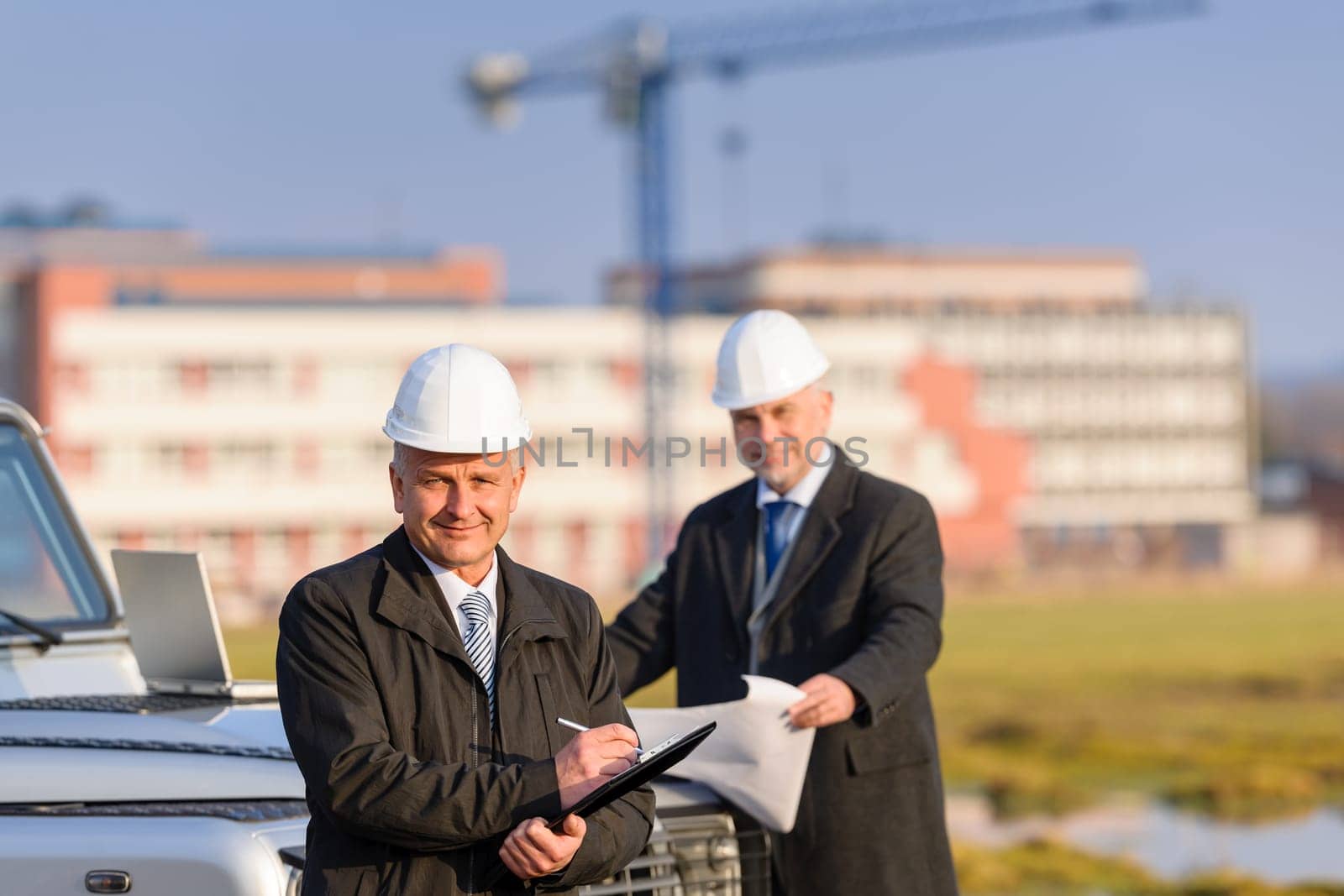 Male architect developers on construction site making notes building project