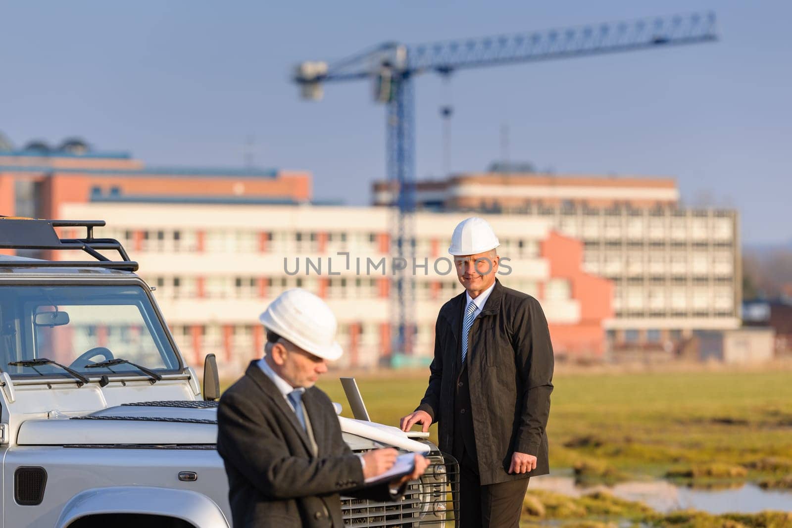 Male architect developers on construction site making notes building project