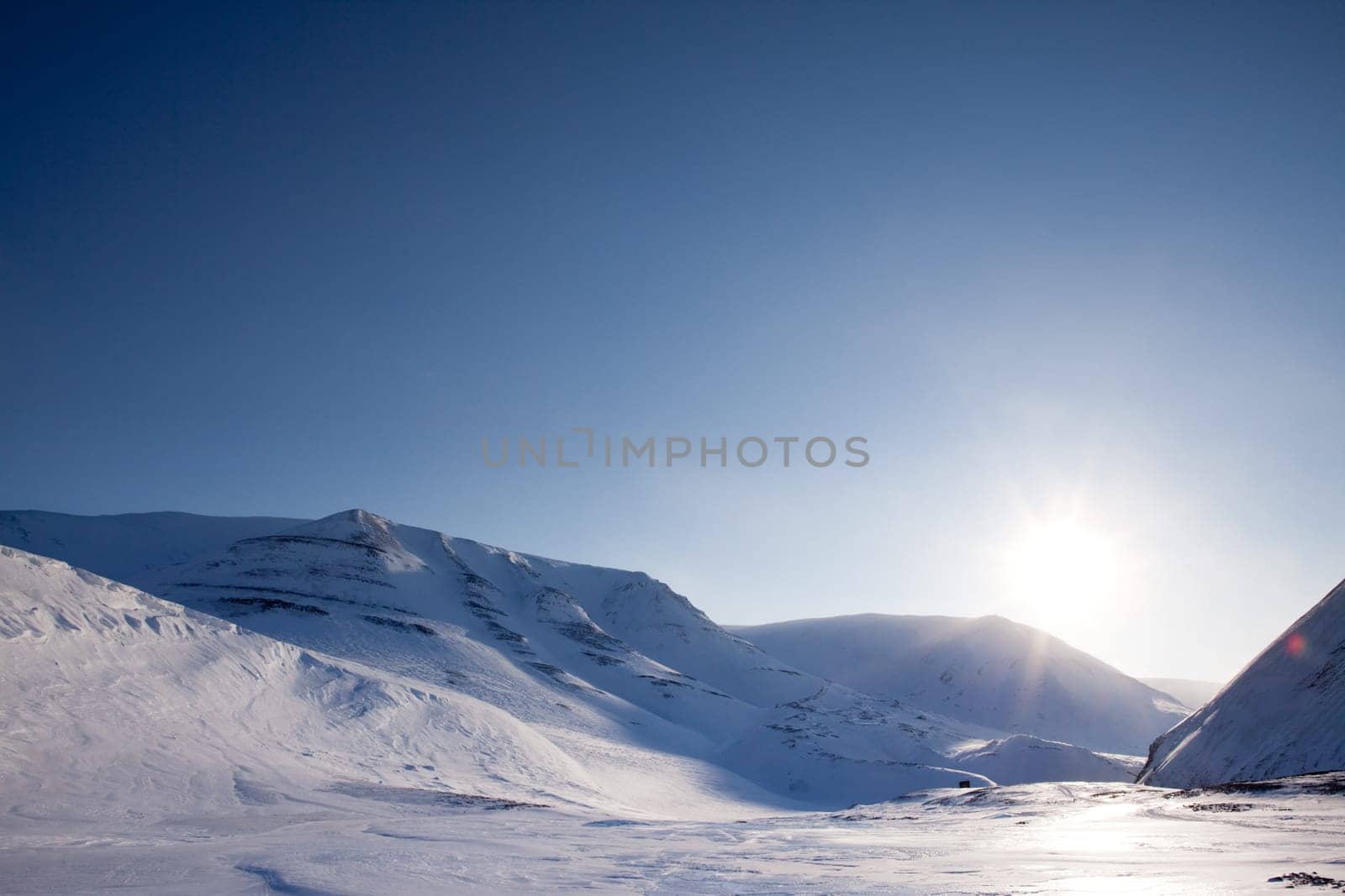 A dramatic winter landscape with snow and mountains
