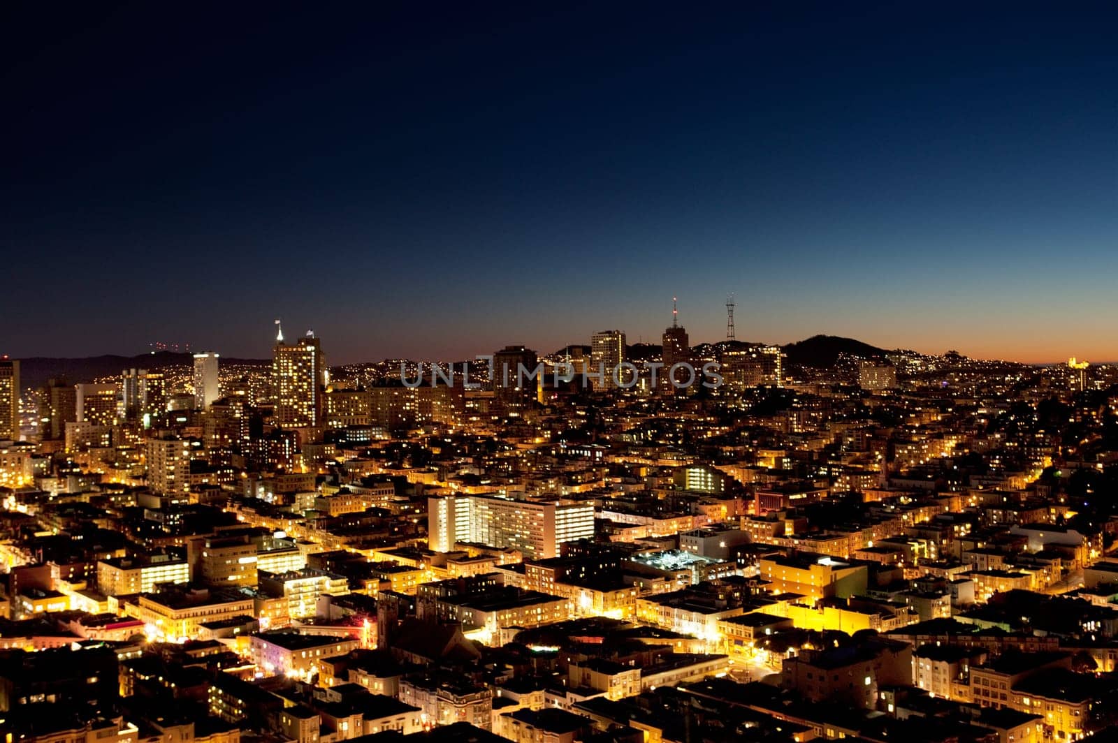 A view of a city at night with a sunset on the horizon - San Jose