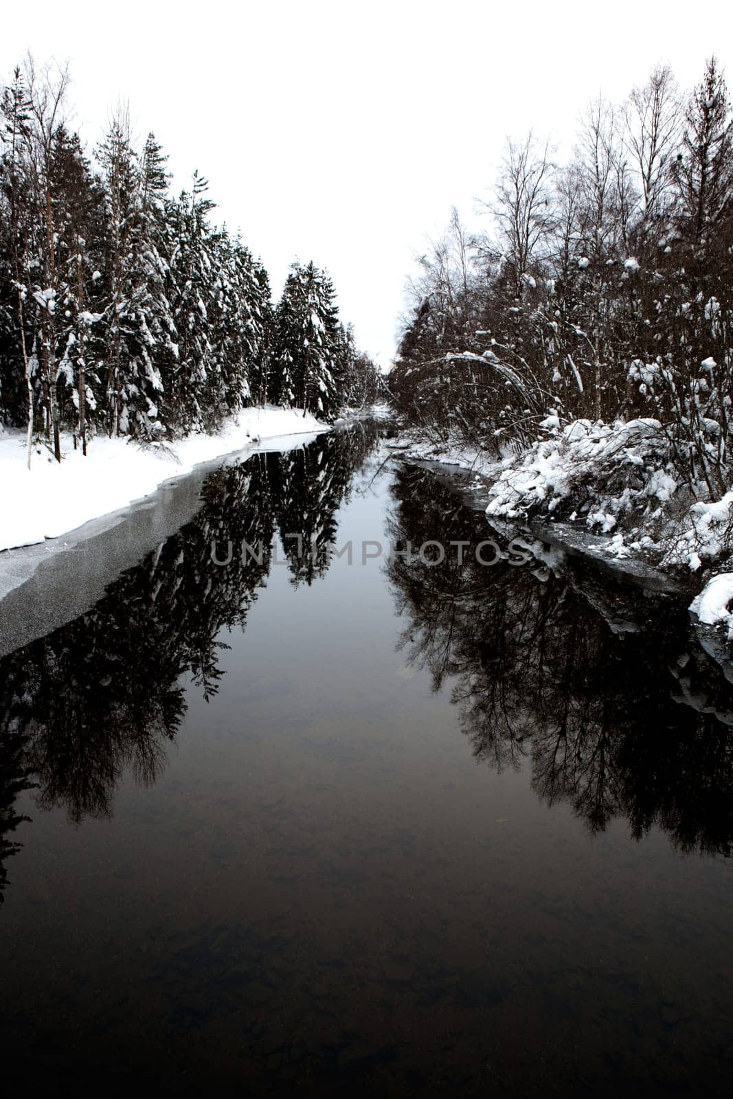 A cold winter river with a grey sky