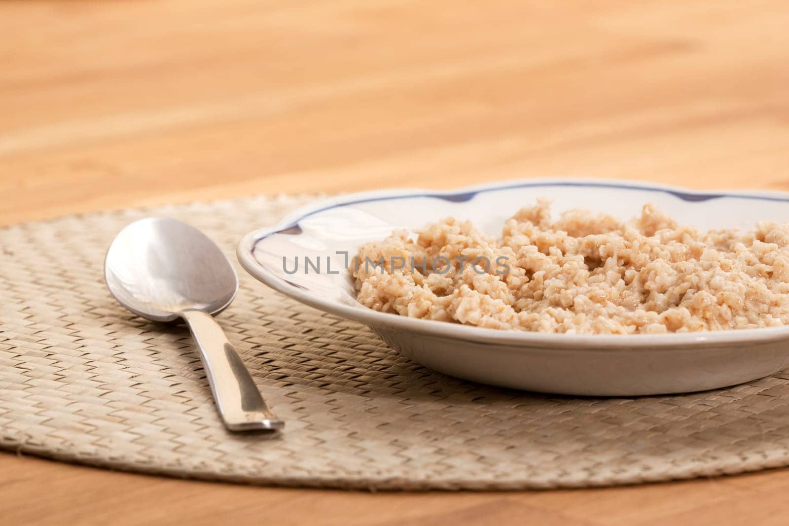 A bowl of porridge on a table with a spoon