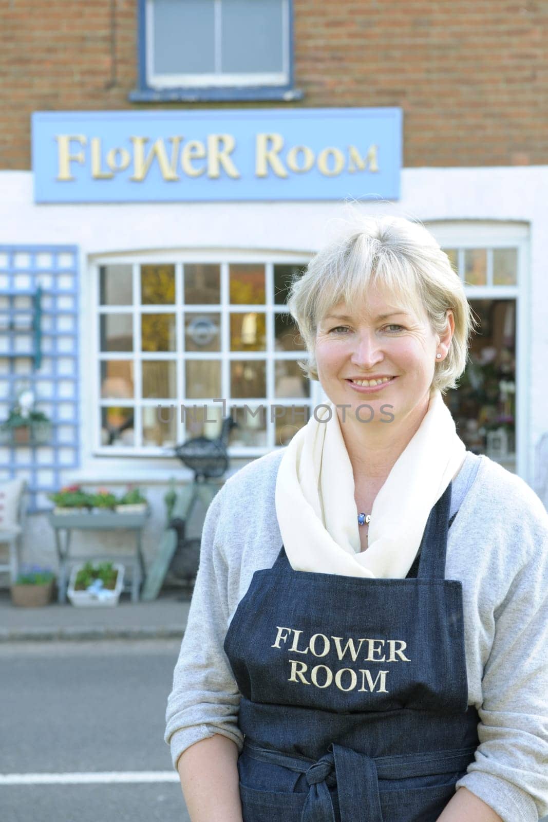 Florist standing outside her shop smiling at camera