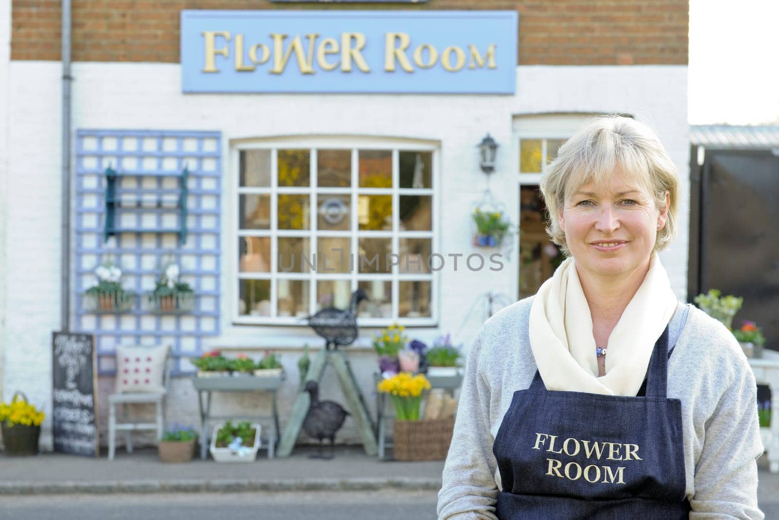 Florist standing outside her shop smiling at camera