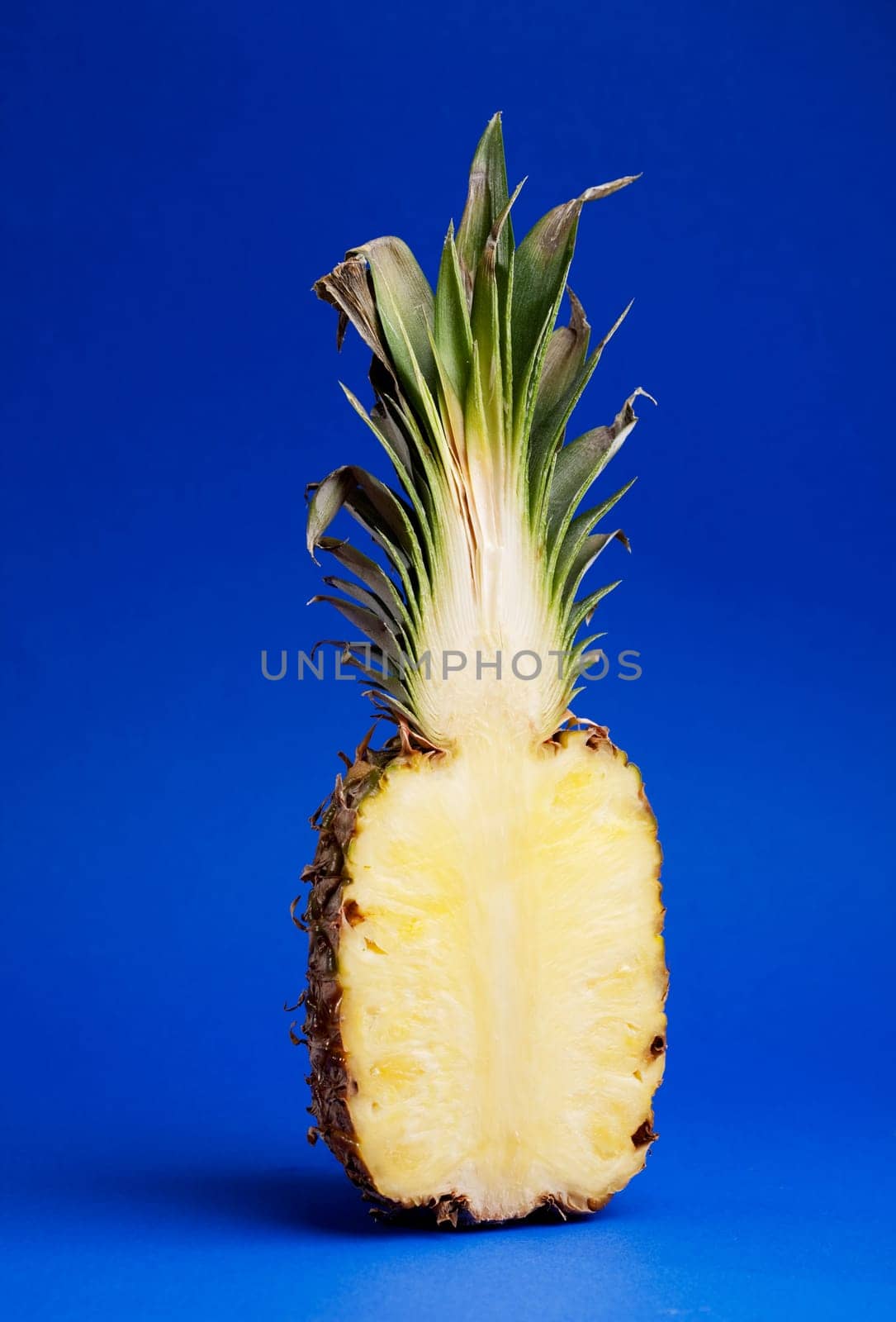 Half of a pineapple isolated on blue