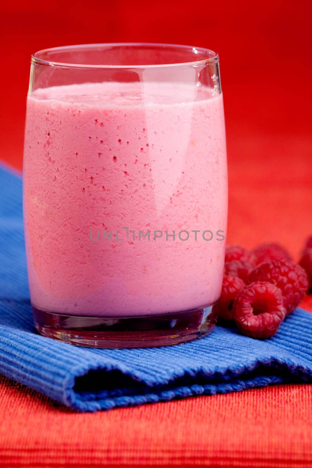 A raspberry smoothie on a red and blue background