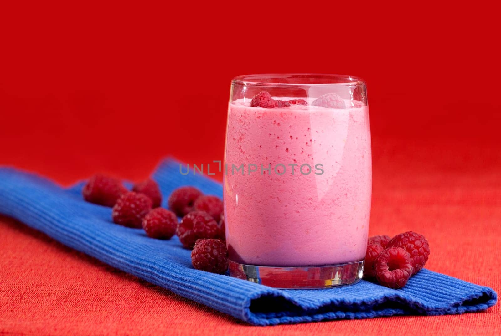 A raspberry smoothie on a red and blue background