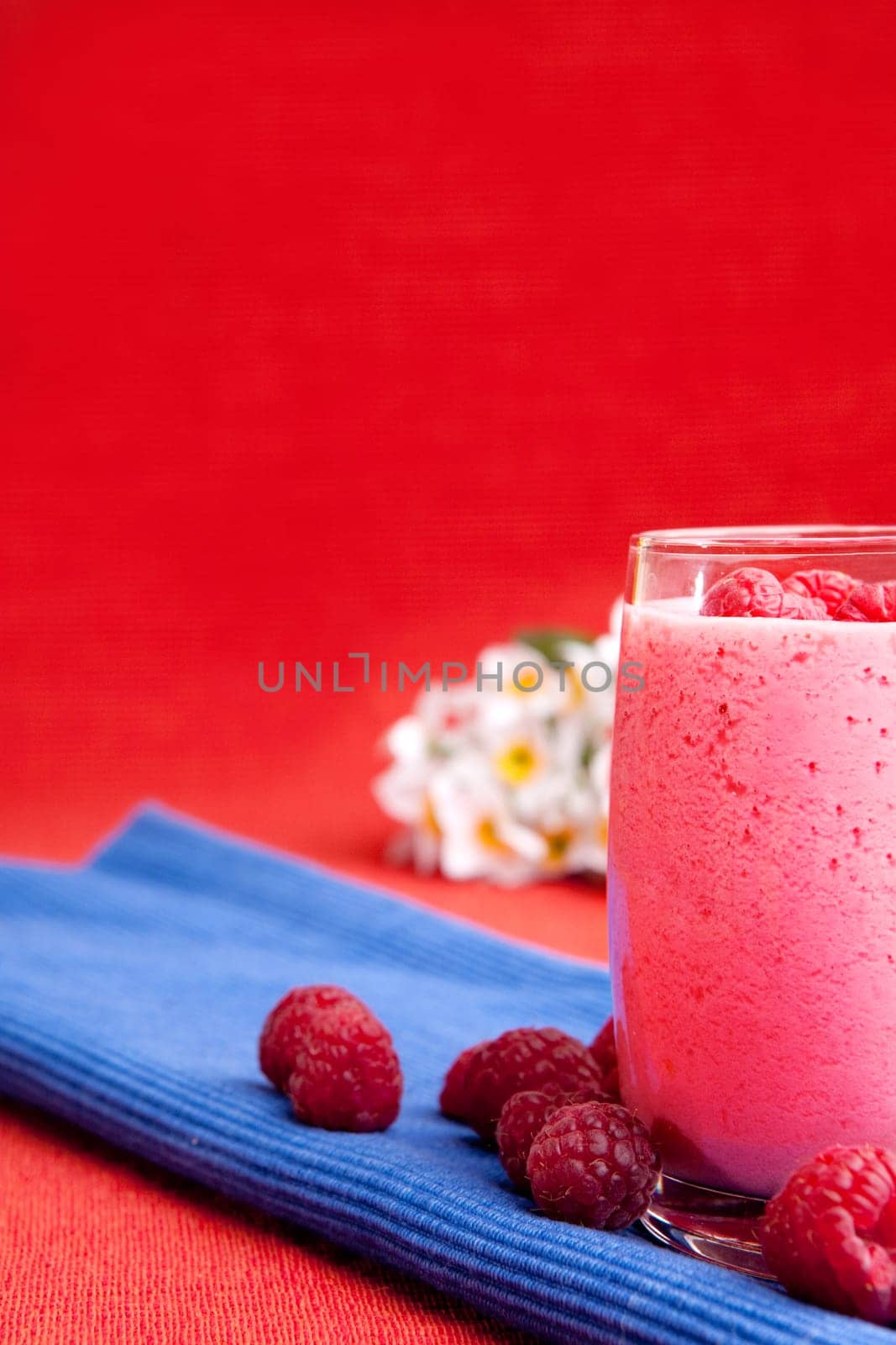A healthy berry drink - raspberry smoothie on red