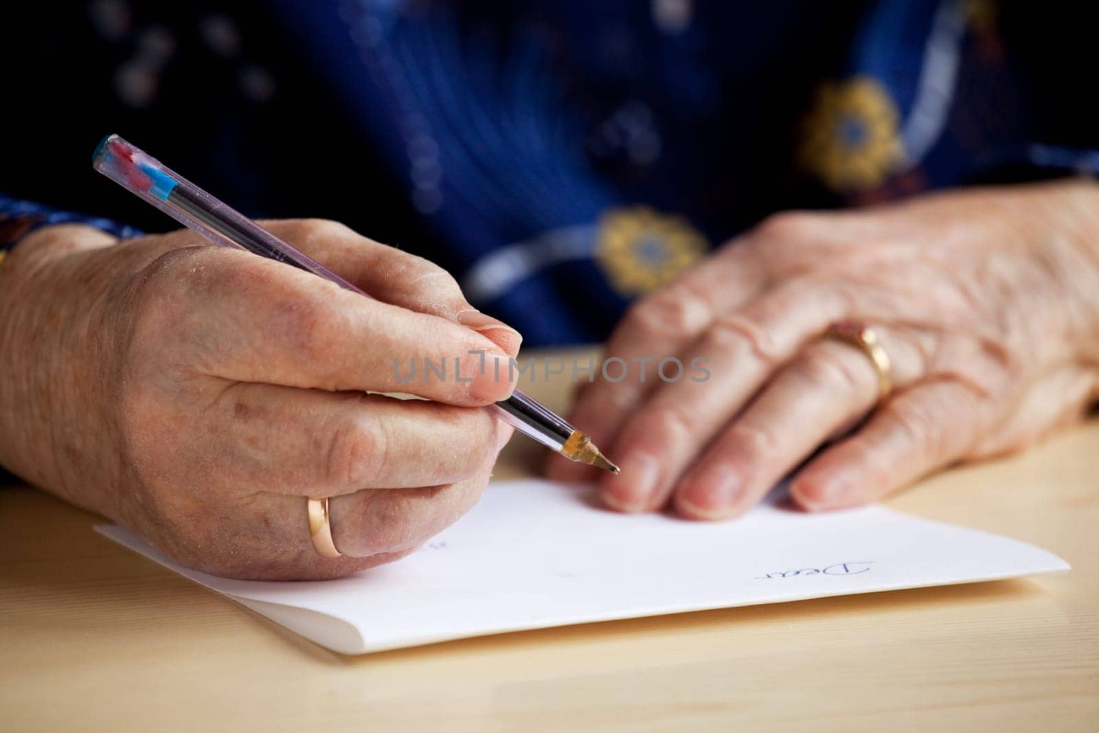 An old pair of hands writing a letter