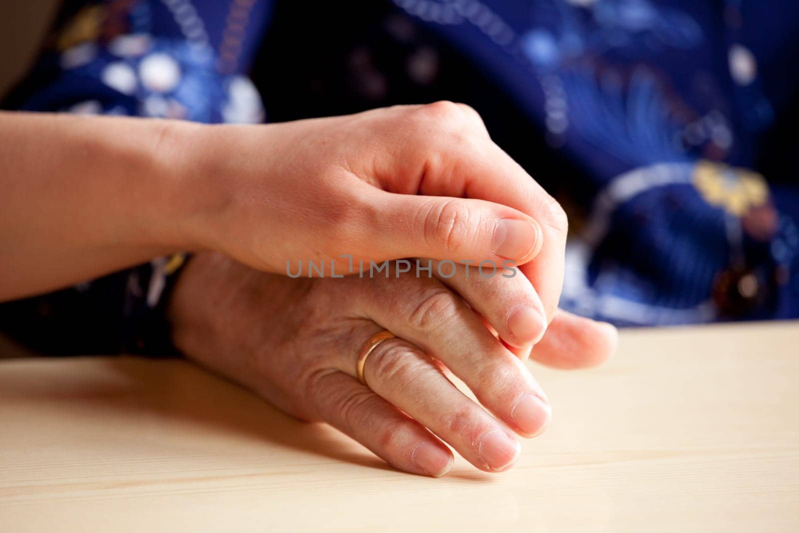 A young hand comforts and elderly hand