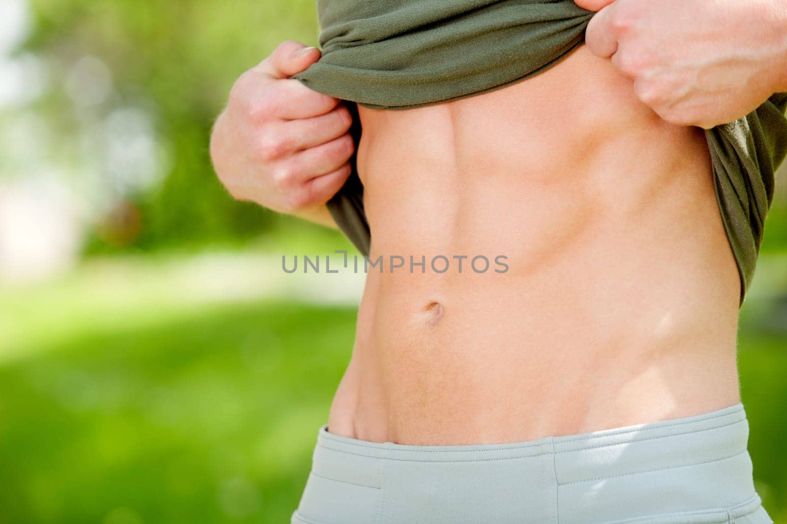 Sexy man showing his six-packs against blur background