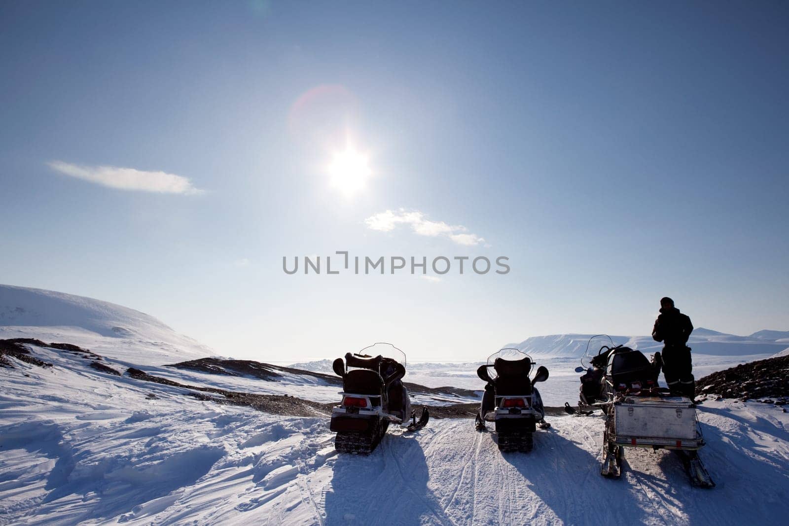 Three snowmobiles on a Svalbard Landscape - winter adventure