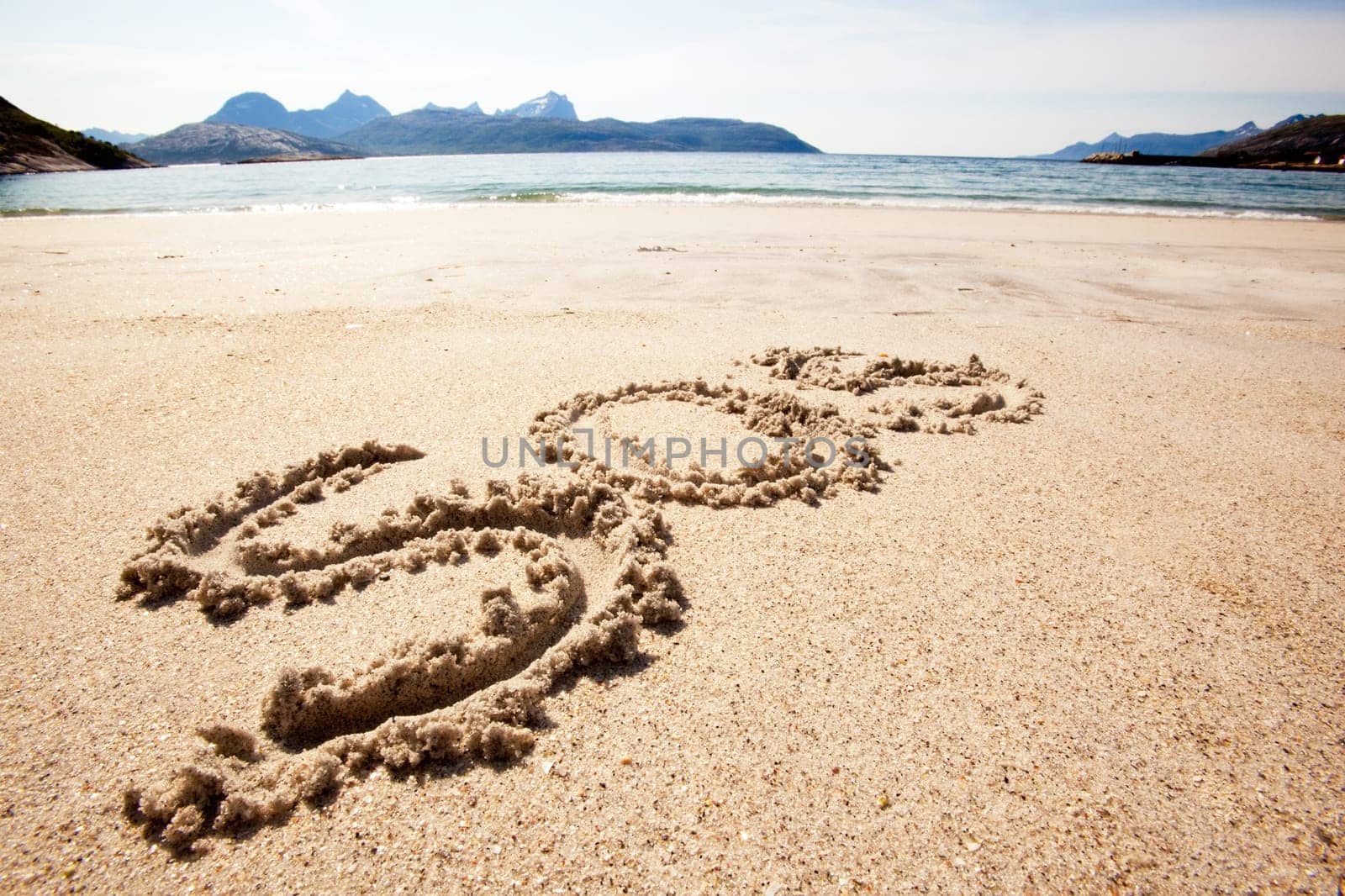 An S.O.S. message in the sand on an island
