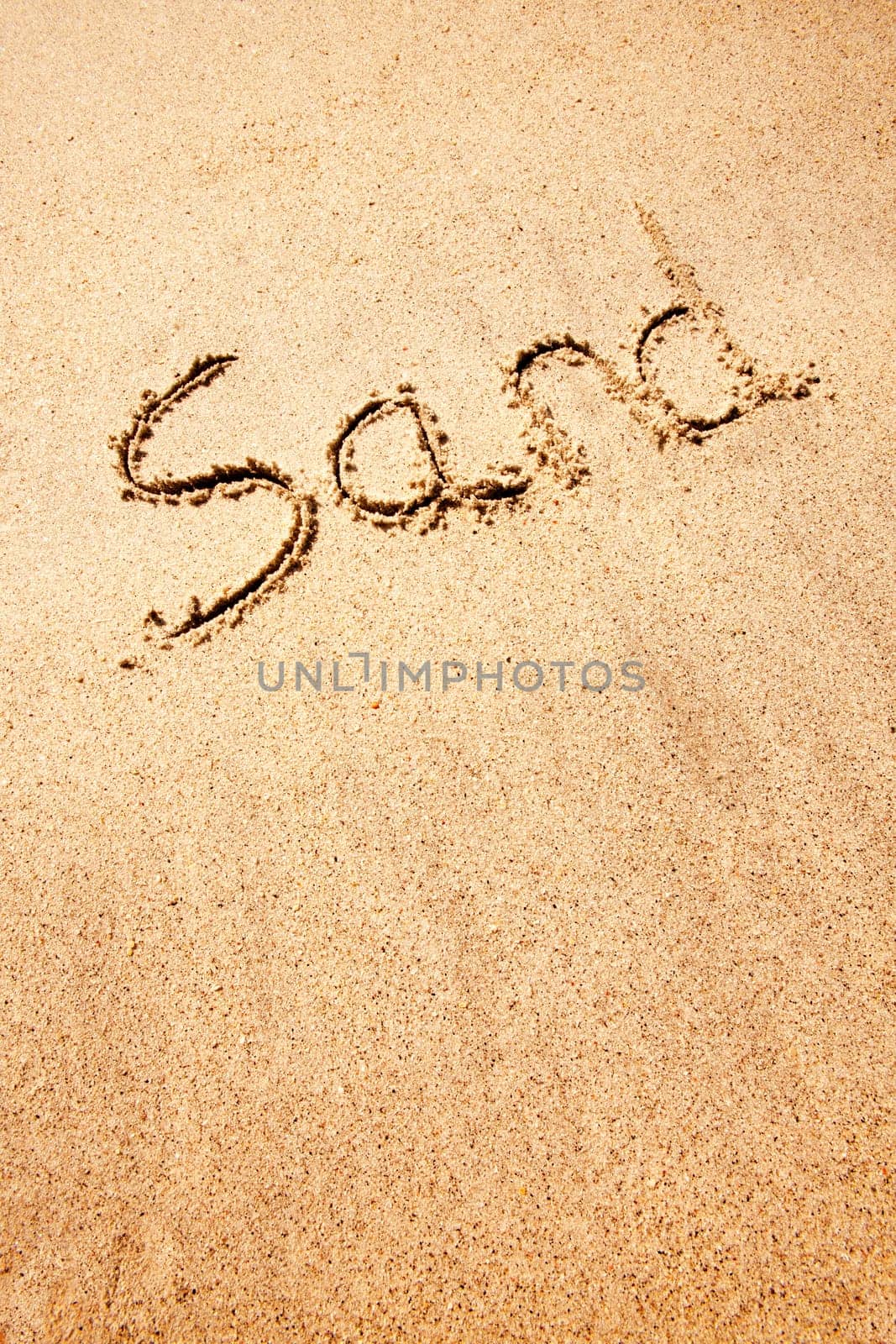 A sand background image with the word written with a stick