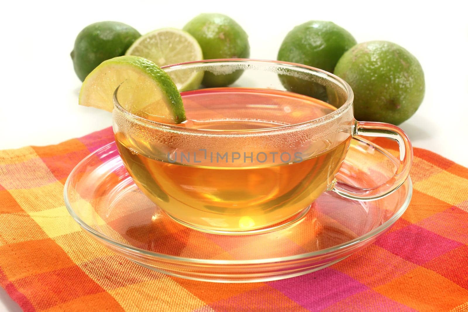 a cup of lime tea with fresh limes