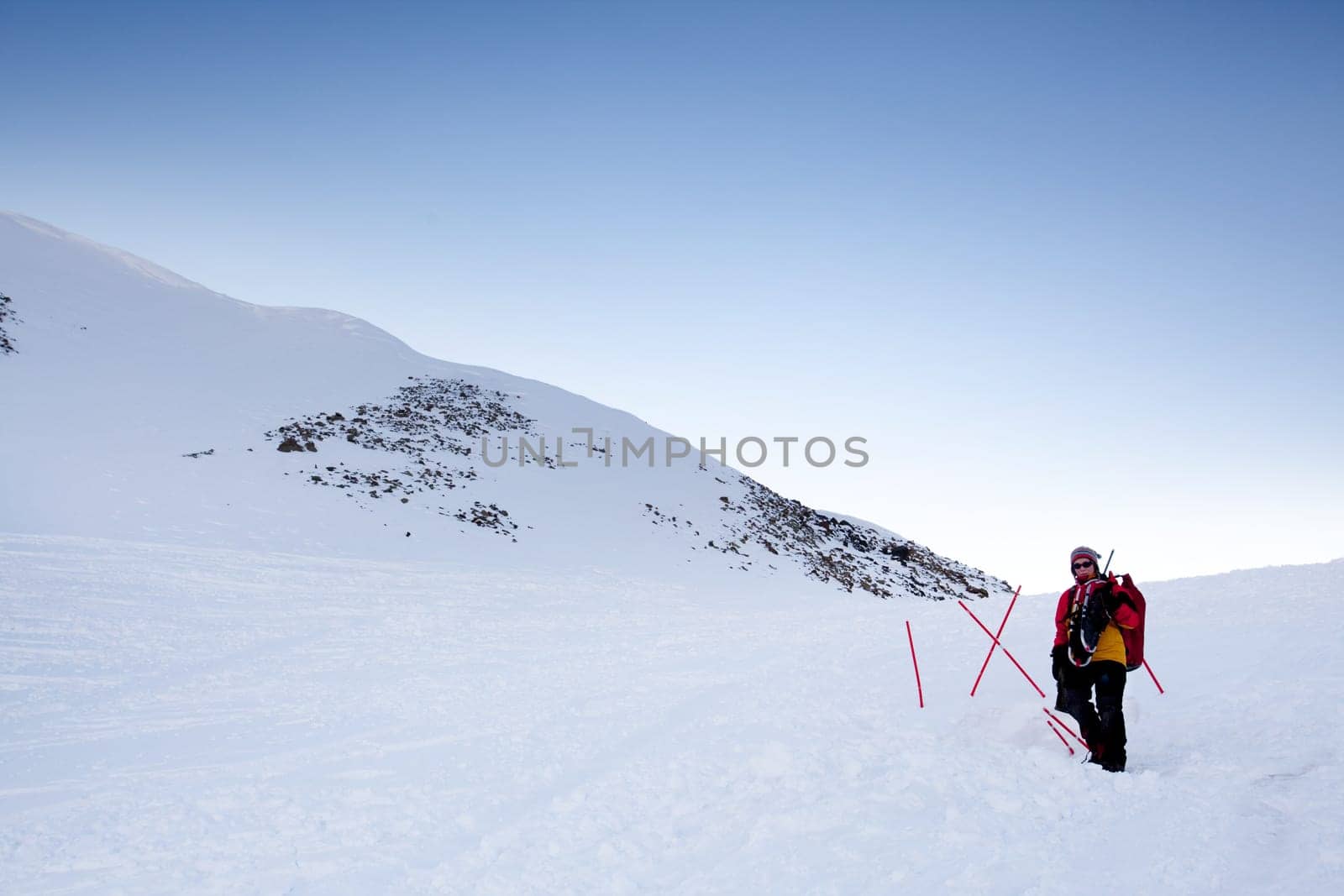 A female mountaineer on a snow filled slope, Svalbard, Norway