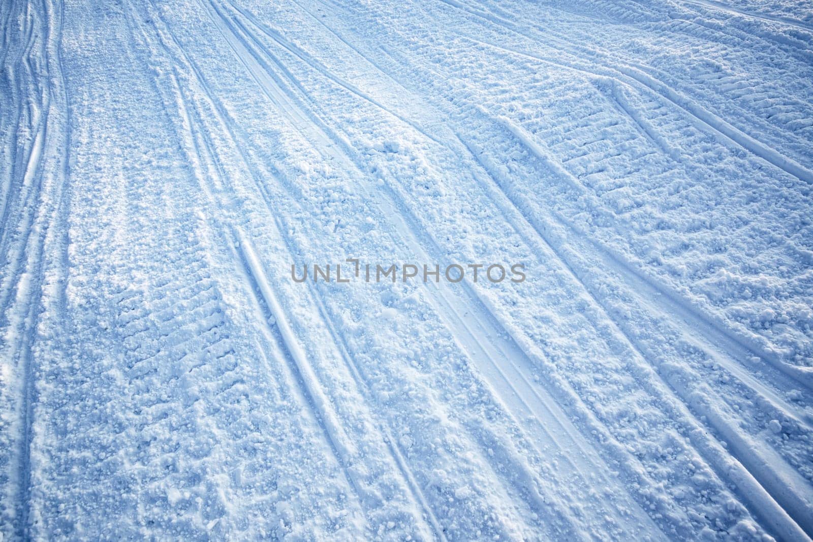 A snow texture of snowmobile tracks converging into the distance