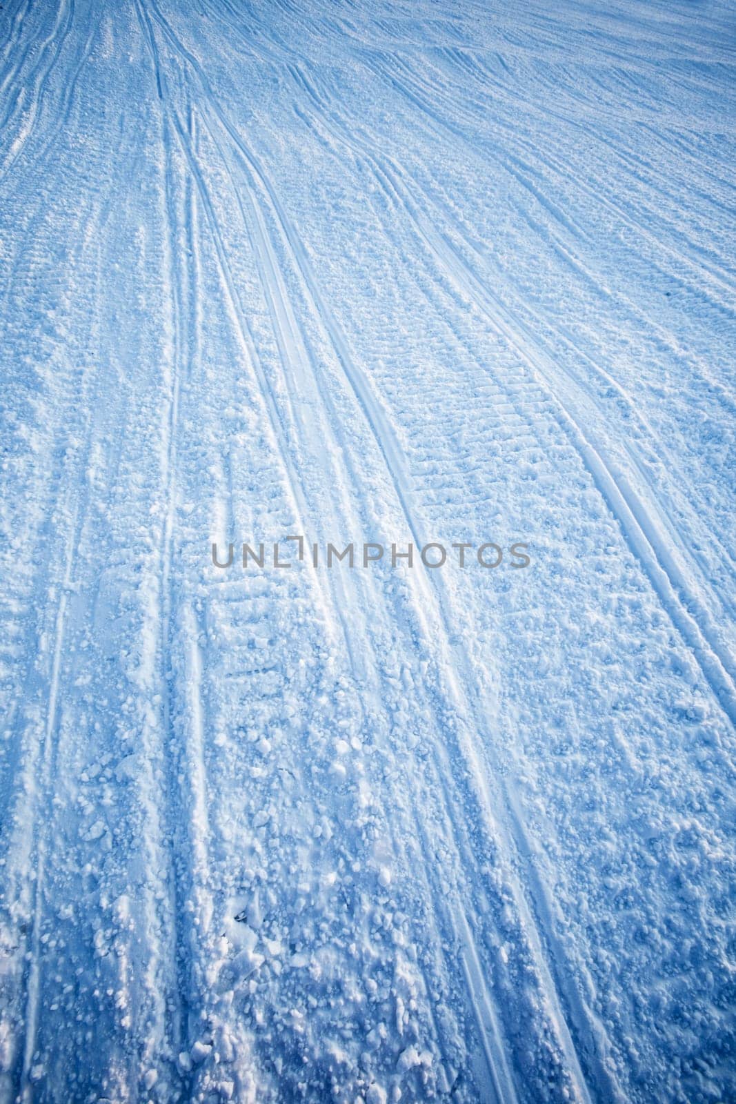 A snow texture of snowmobile tracks converging into the distance