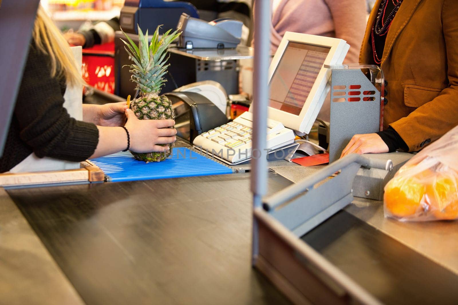 Midsection of shop assistant and customer in the supermarket