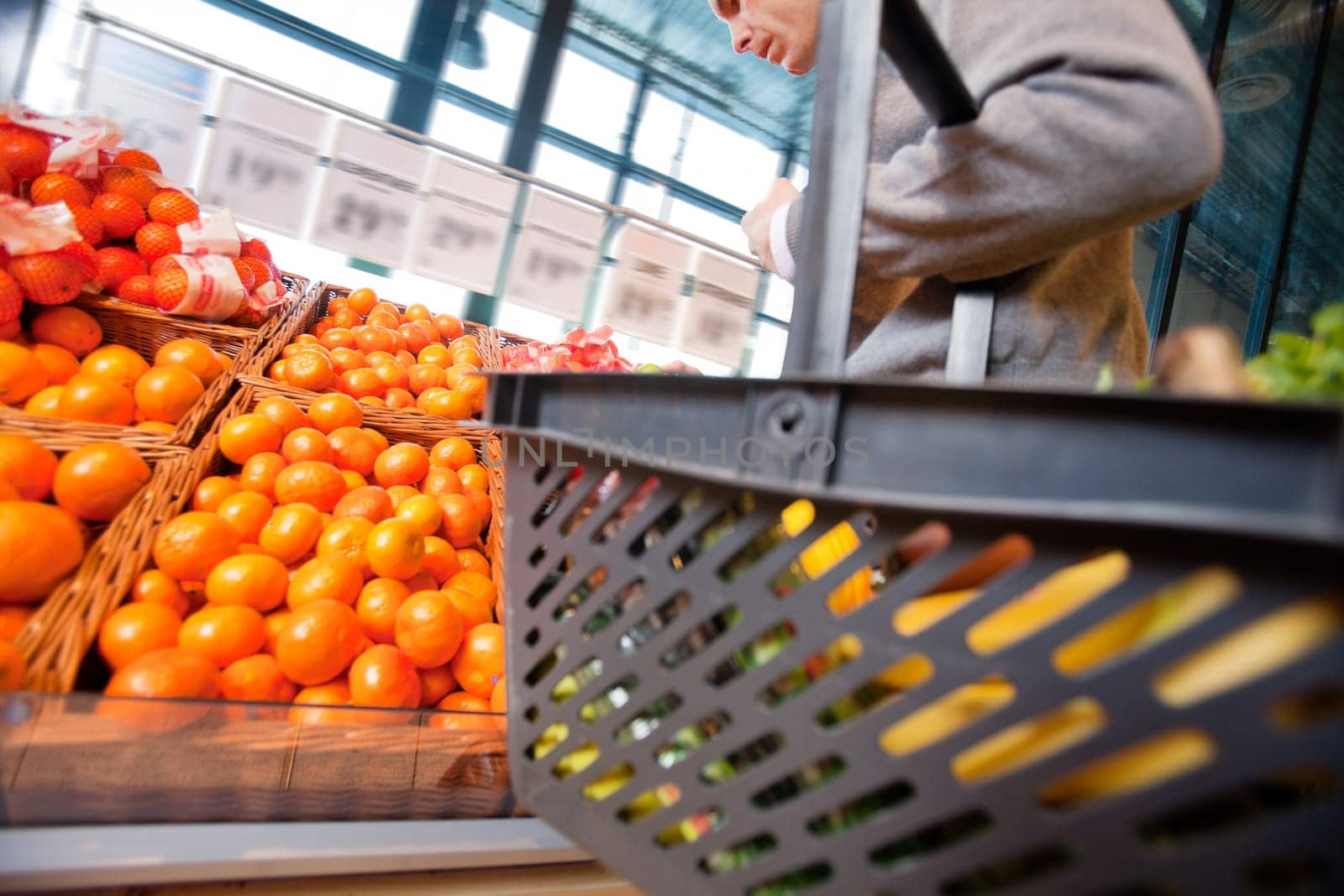 Closeup of a man carrying basket while buying fruits in the supermarket