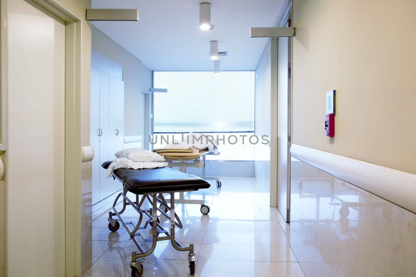 An intrior of a hospital hallway with a couple stretchers