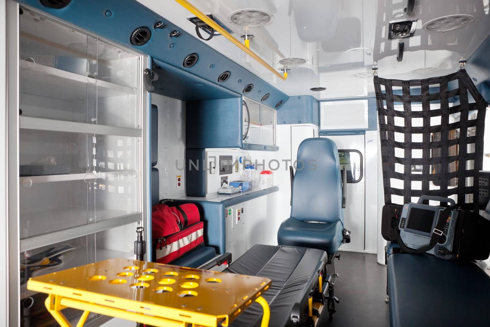 Empty ambulance interior with equipment on bench