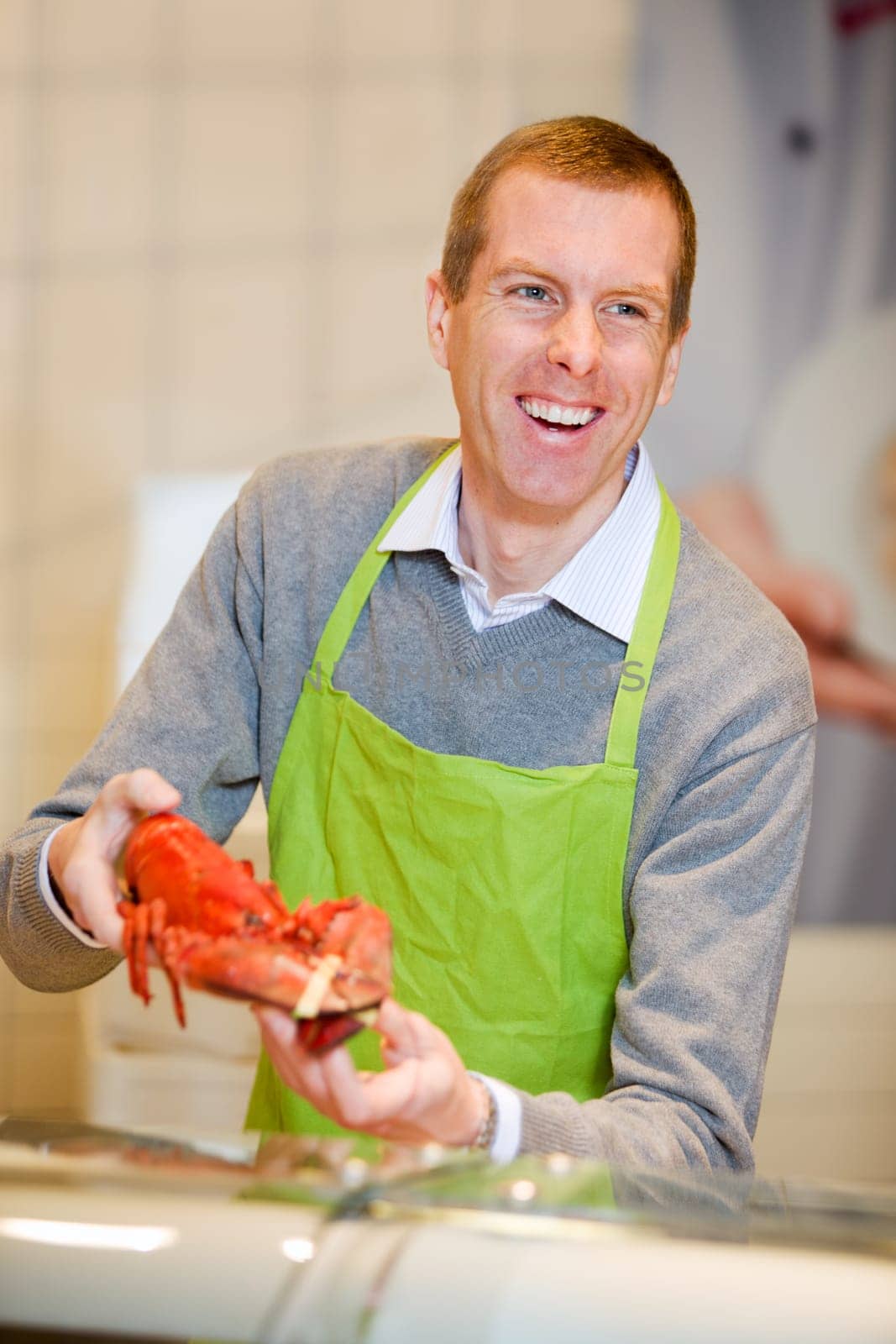 A man at a grocery store selling a lobster