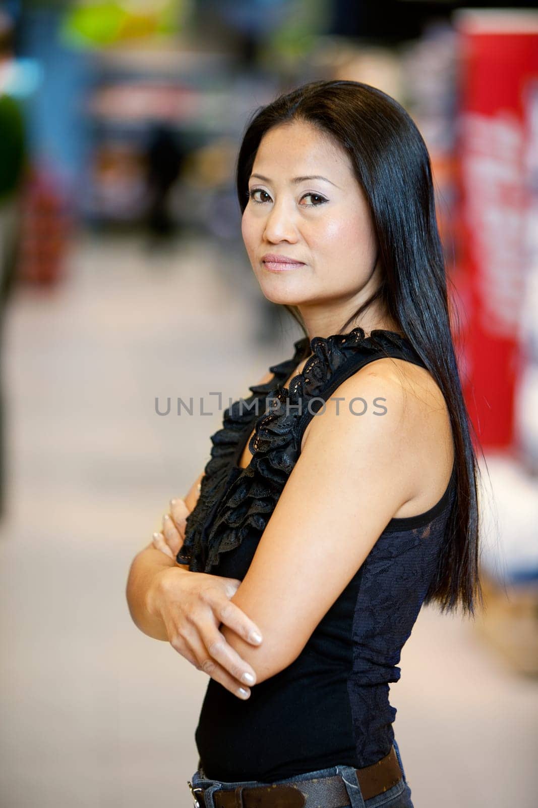 Asian woman standing in a supermarket looking at the camera