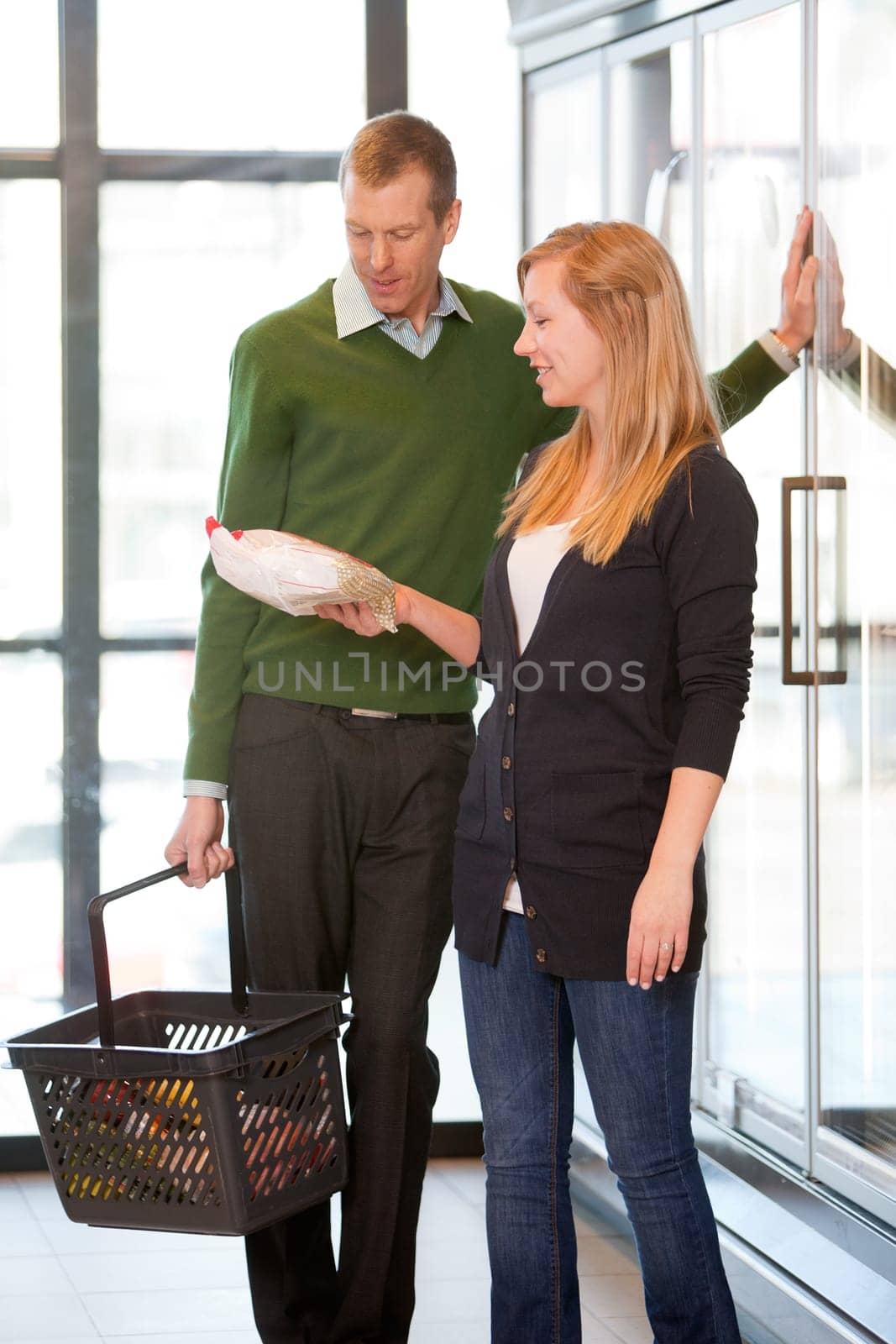 A happy couple buying frozen food in a supermarket