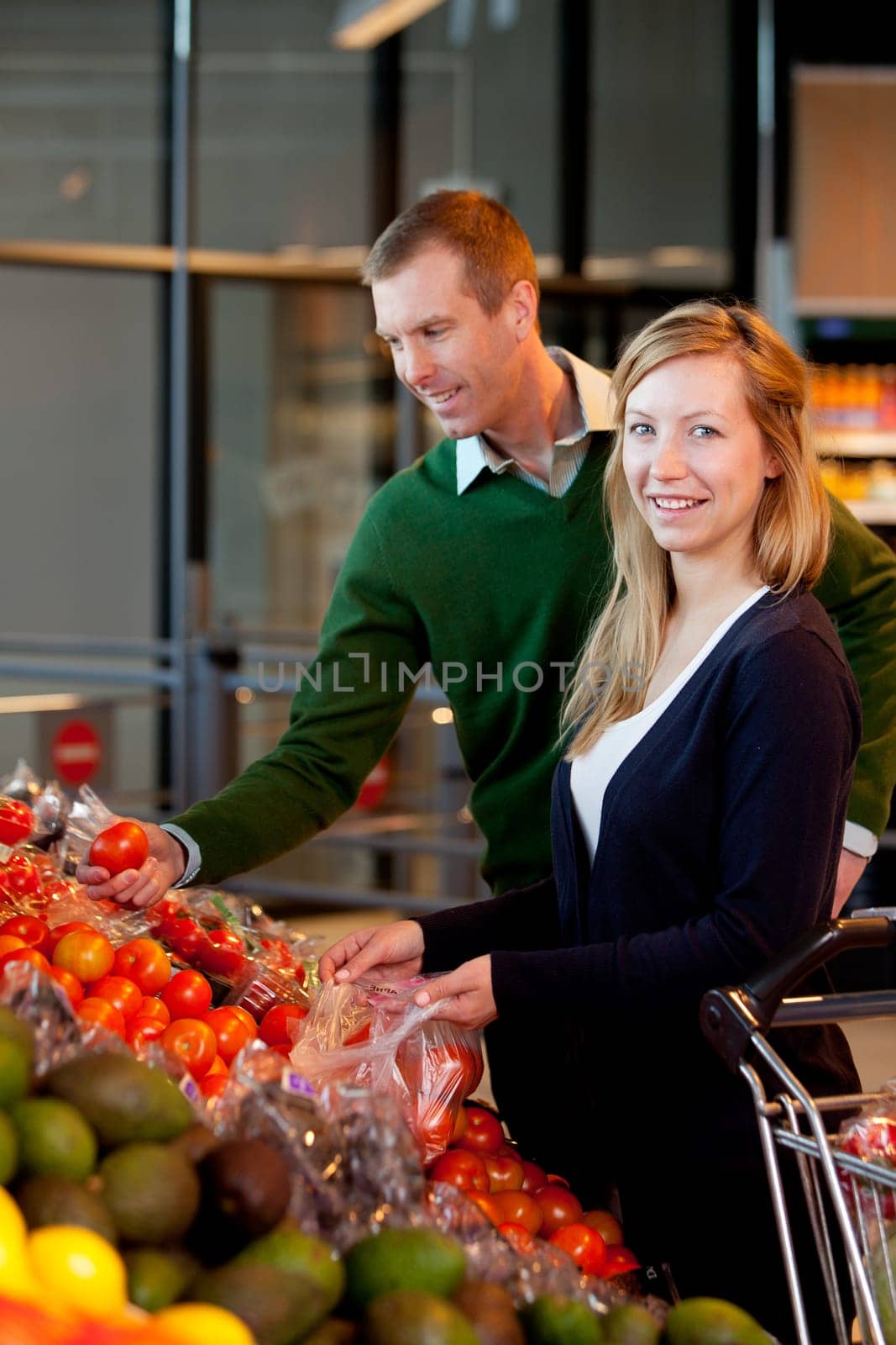 A happy couple buying fruit and vegetables in a supermarket