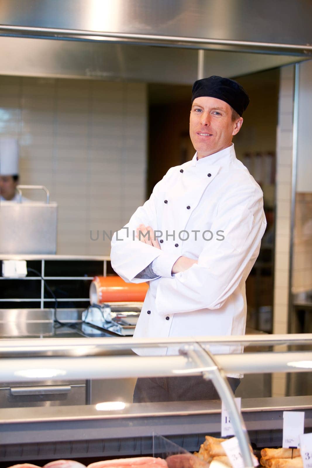 A butcher standing behind a fresh meat counter