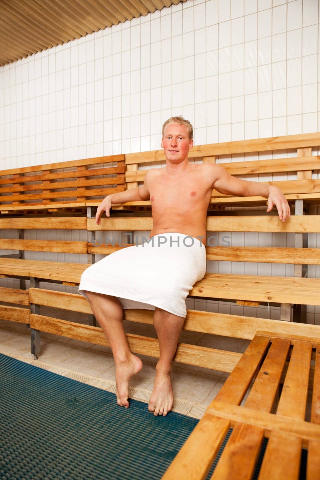 Portrait of a happy man sitting in a sauna