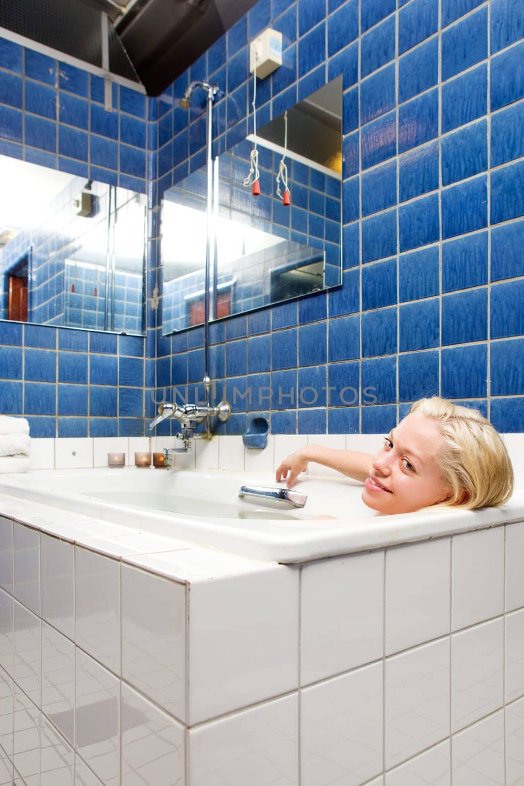 A woman taking a luxury bath cure in a old 20s style spa