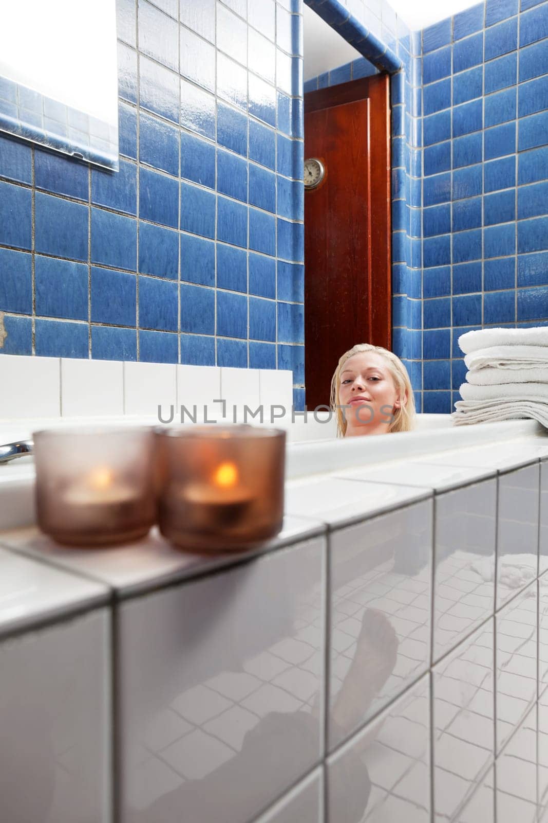 Beautiful woman in bathtub at luxury spa with candle in the glass