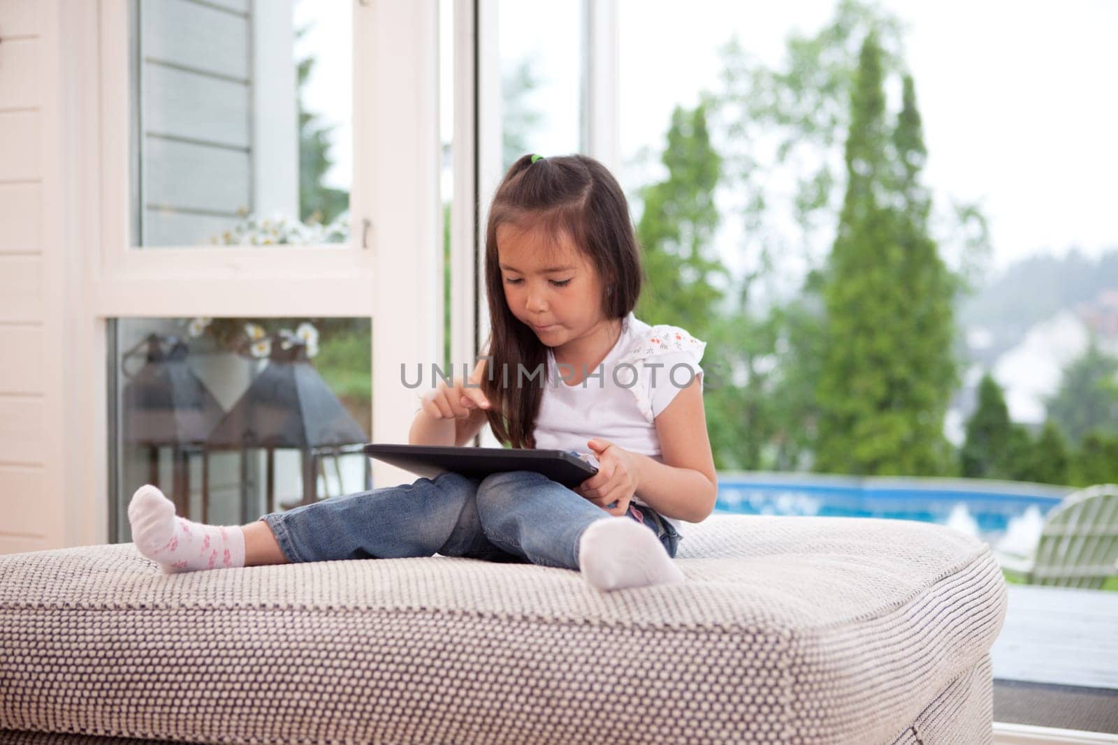 Happy young child playing with a digital tablet in an indoor setting